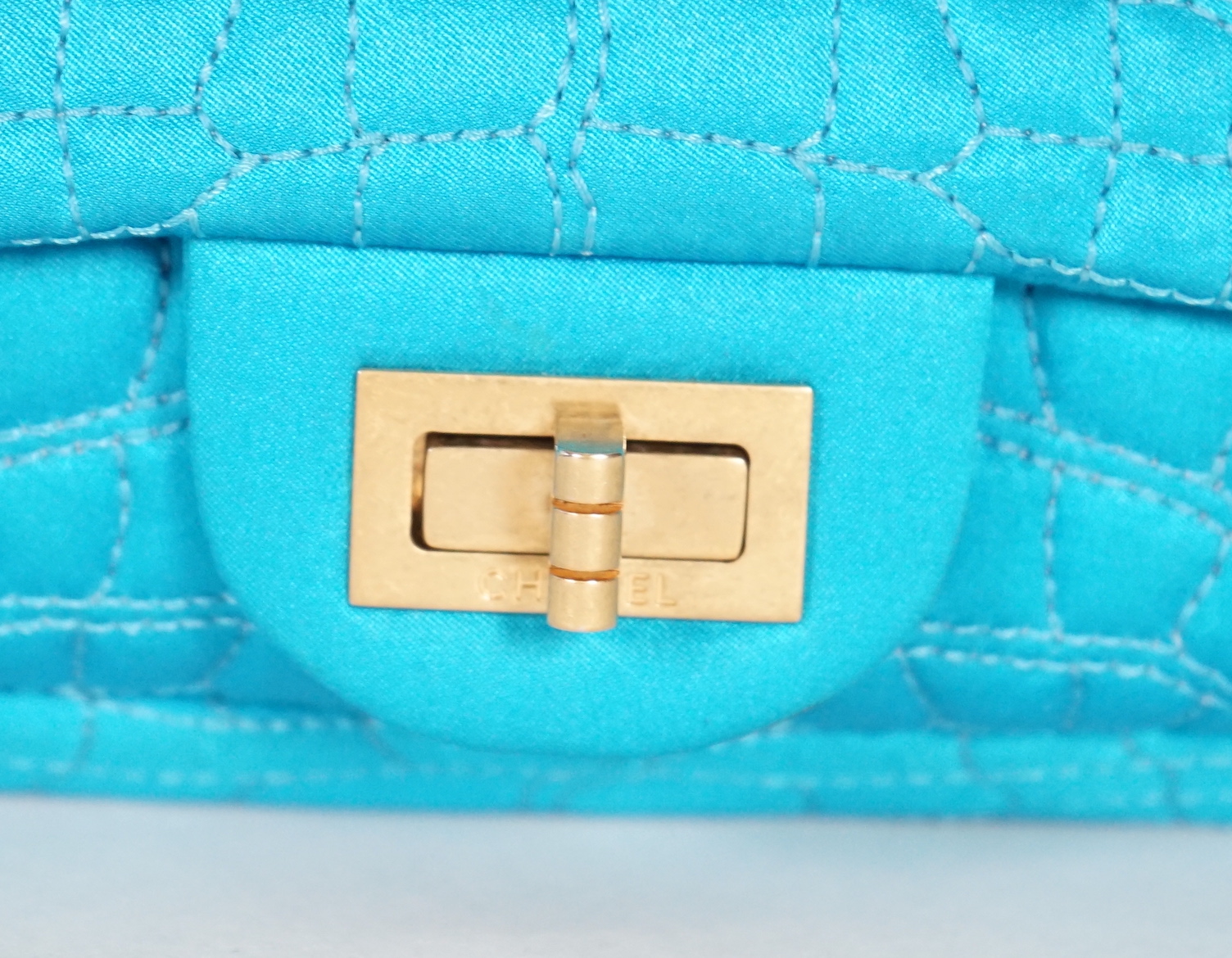 A Chanel medium-sized 2-55 bag in turquoise blue silk satin stitched with a quilted crocodile pattern, width 24cm, height 15cm, depth 6cm, Single handle 112cm, Double handles 65cm